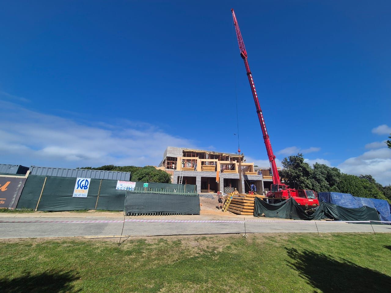 Mobile crane lifting timber panels into place on the Driftwood House site