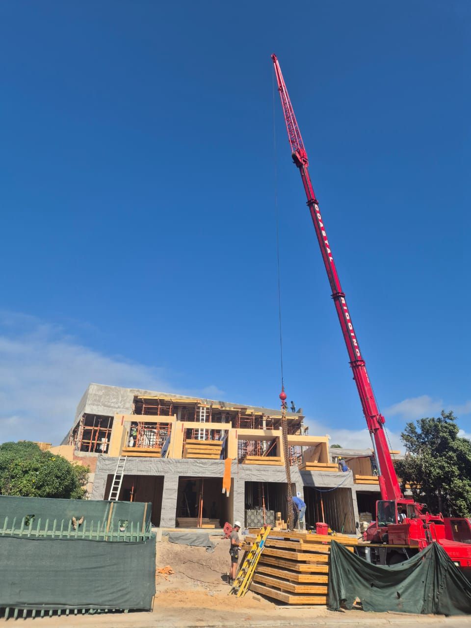 Red crane boom above the timber-framed upper storeys