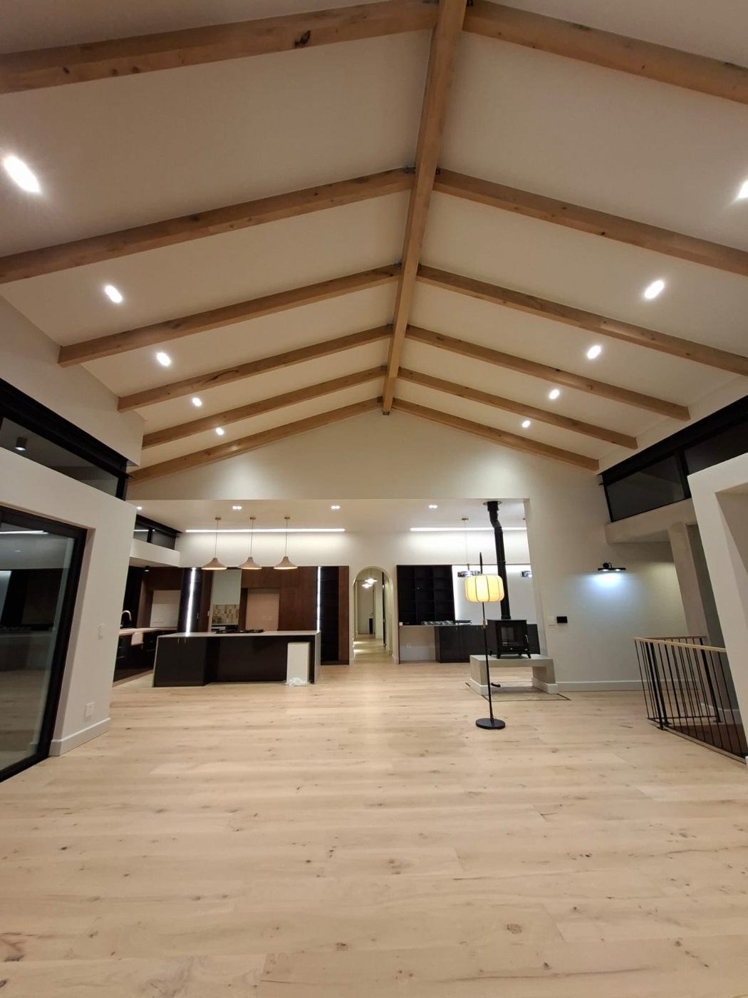 Open-plan living room with exposed roof beams at House - Linkside