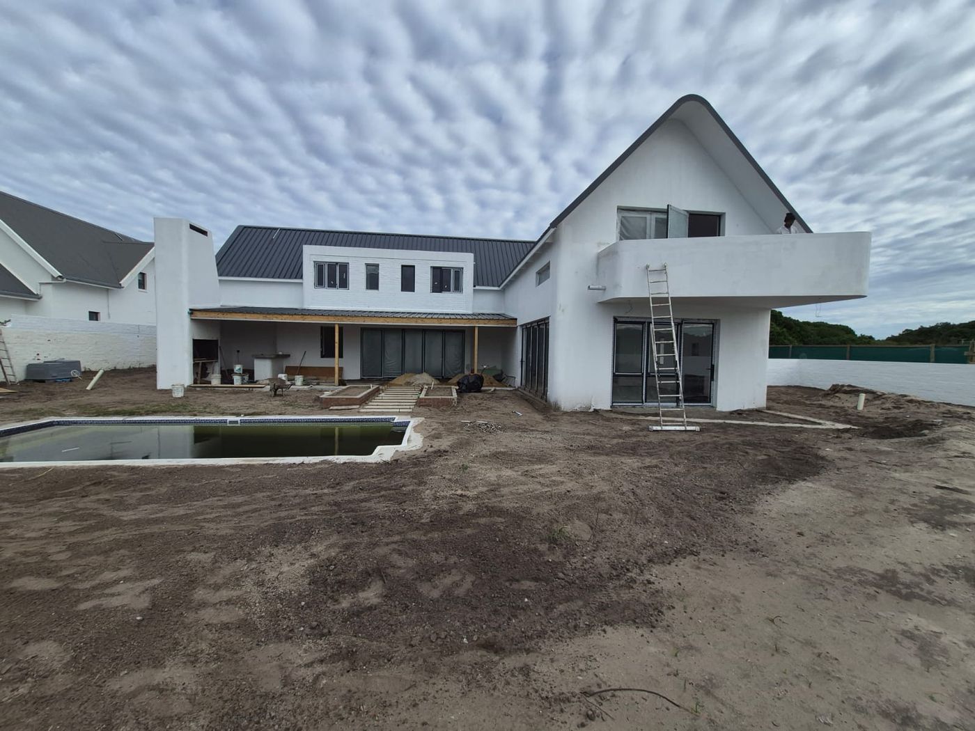 Rear of House Thompson with its gable, balcony and chimney, landscaping still to be done