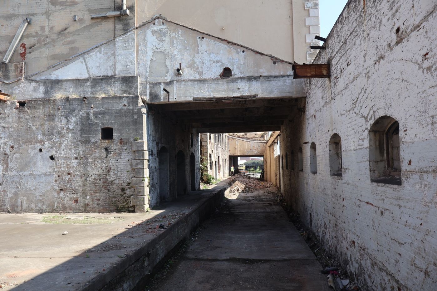 Narrow passage between mill buildings running under a covered bridge