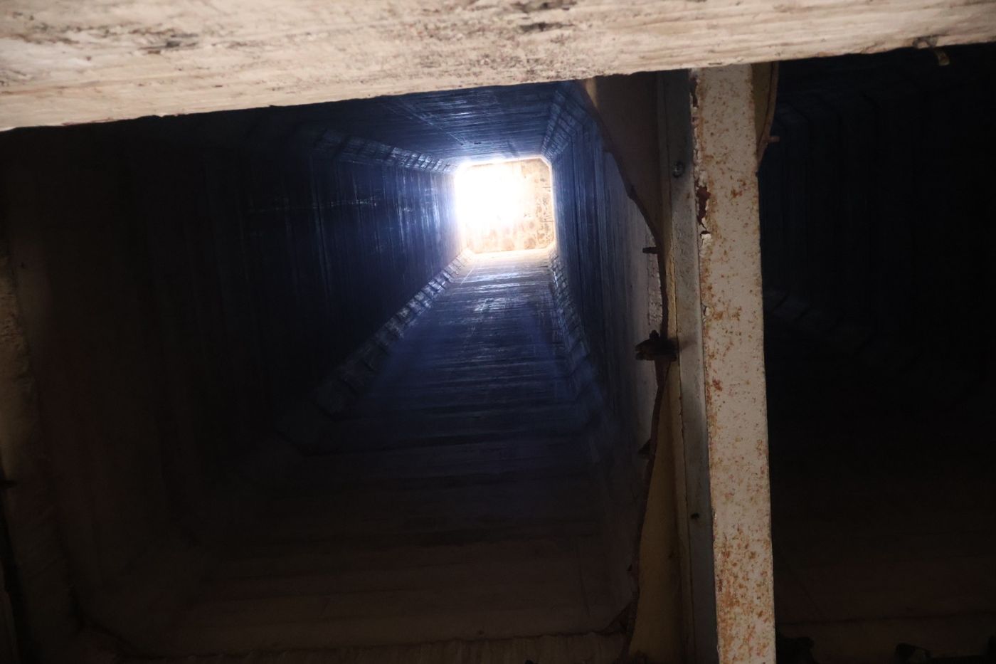 Dark timber-lined shaft inside the silo structure, lit from one end